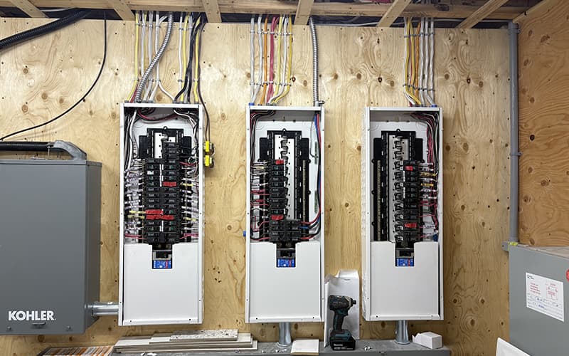 Installation électrique réalisée par Éric Leroux Électrique — trois panneaux électriques neufs câblés côte à côte