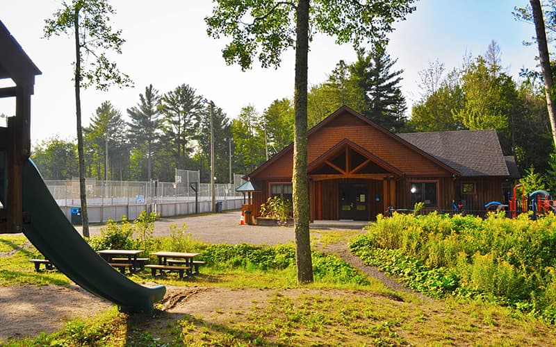 Bâtiment communautaire en bois près d'un parc et de terrains de sport