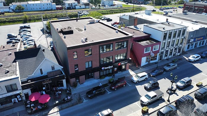 Vue aérienne d'un centre-ville avec commerces et stationnements