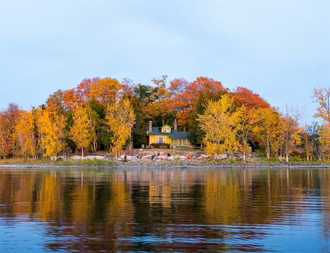 Maison au bord d'un lac, arbres aux couleurs d'automne